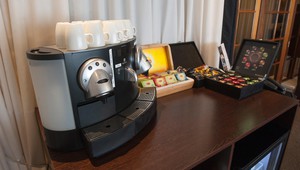 Nespresso machine and refrigerator filled with water and soft drinks